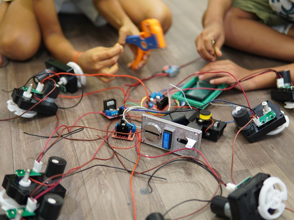 Cubo Academy children's hands sorting motors, circuit boards and wires for their build