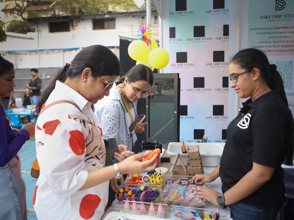 A Cubo Academy child showing her creations to customers at her own market stall